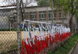 flaga ze wstążek zawieszonych na ogrodzeniu szkoły