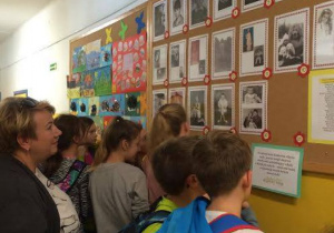 Uczniowie przed tablicą ze zdjęciami